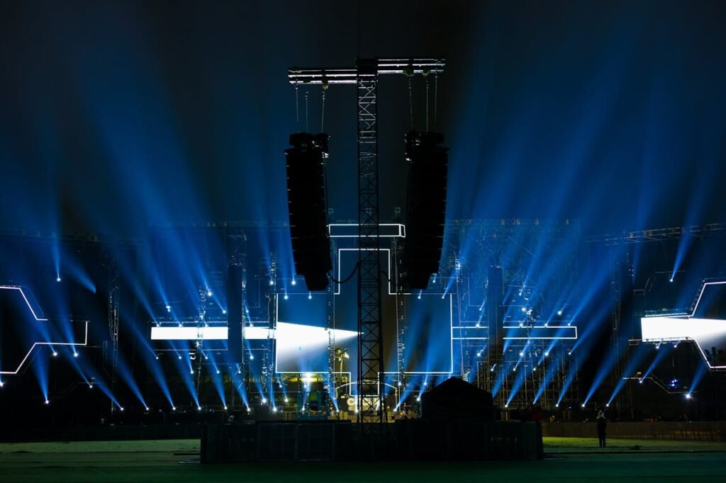 Nighttime concert stage illuminated by vibrant blue lights.