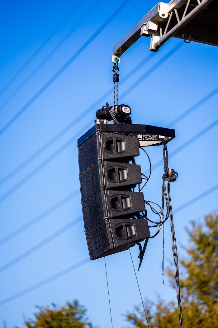 Large line array speakers suspended outdoors for a concert event.